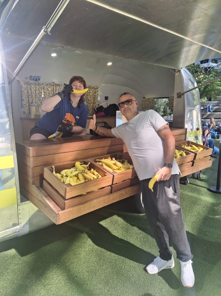 I bananistas sorridenti che regalano banane fresche ai passanti dal chiosco Community Banana Stand di Amazon, cosa fare a Seattle di insolito